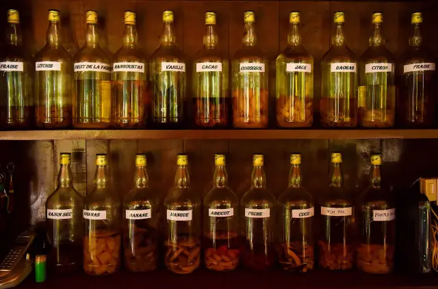 Étagères de bouteilles de rhum arrangé aux fruits et aux épices